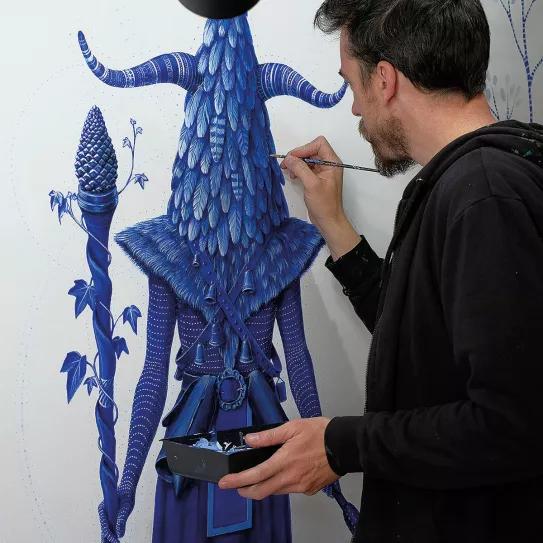 Juako en su estudio pintando Mascarada I, la que abre las puertas, acrílico sobre lienzo, 200x100 cm, 2019
