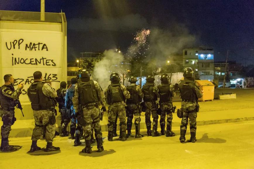 Hombres de las fuerzas de choque de la Policía Militar de Río disparan bombas de gas hacia una de las entradas del Complexo de Maré, después de una protesta contra la ocupación militar y la UPP