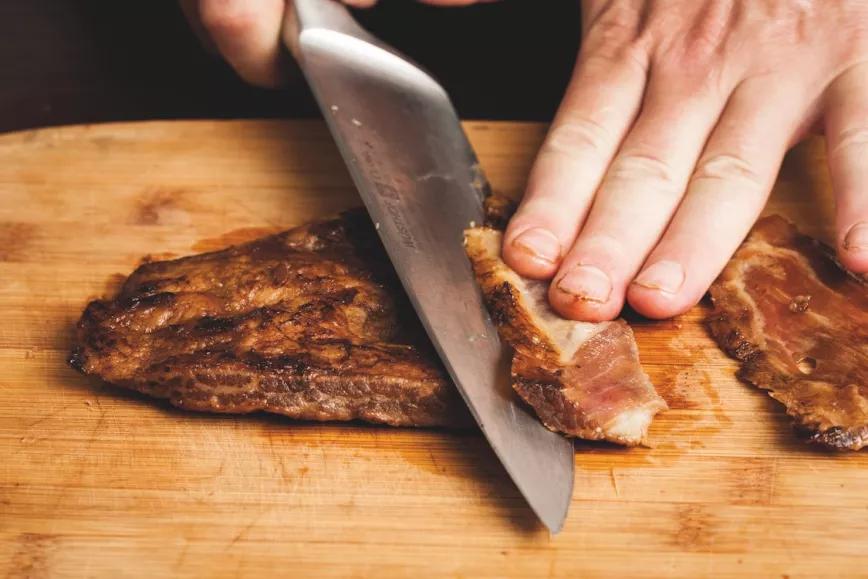 Persona cortando en lonchas un secreto ibérico
