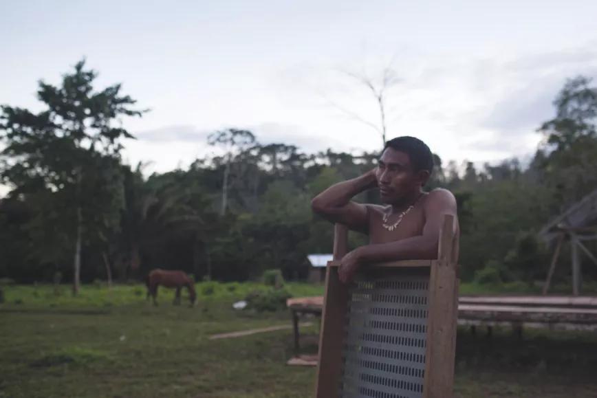 Archia, un hombre descansa en el patio de su casa a la hora del atardecer después de la selección del cacao