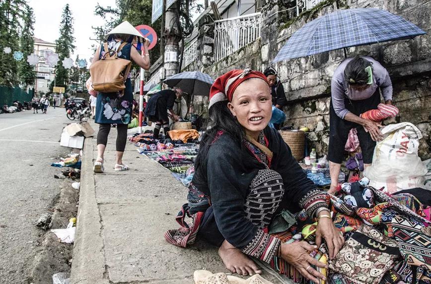 Mujer vendiendo en mercado callejero en Sa Pa