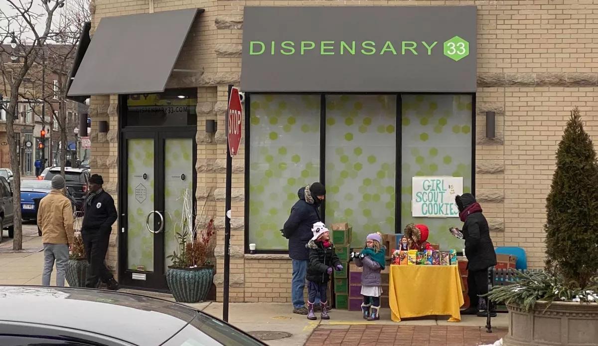 Un clásico: niñas scout venden galletas de exploradora frente a dispensario