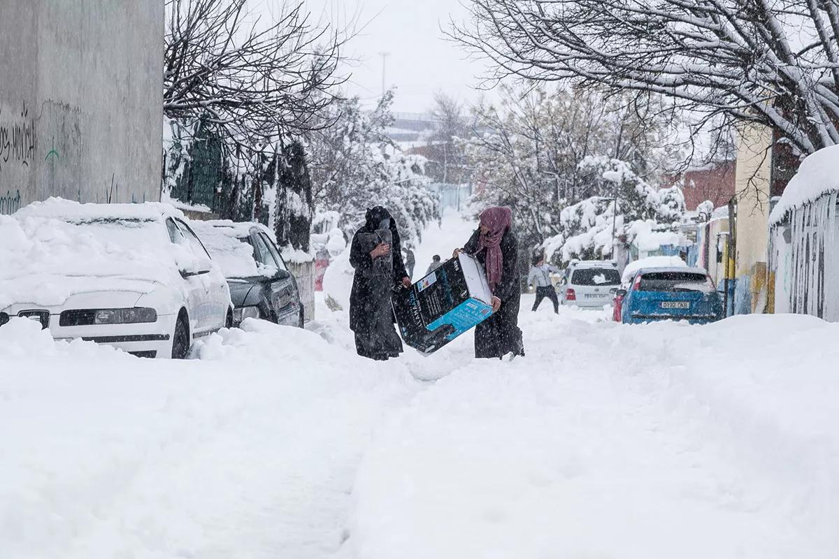 Dos vecinas del Sector 4 transportan un calentador de gas. 