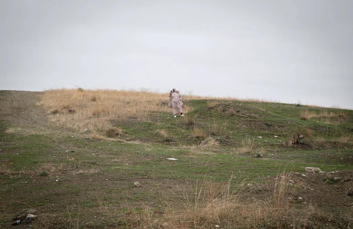 Una vecina fotografía con su teléfono móvil la manifestación contra los cortes de energía eléctrica en la Cañada Real