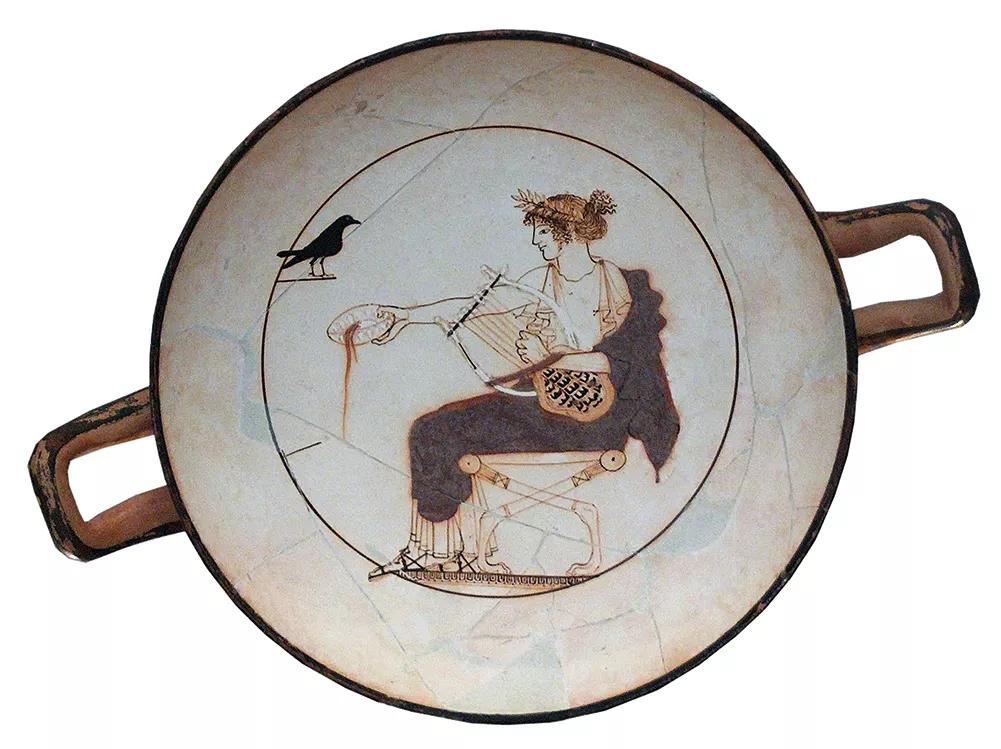 Copa del museo de Delfos en cuyo fondo se representa al dios Apolo ofreciendo una libación a un cuervo negro. Apolo no es Dioniso, dios del vino e inspirador de la locura ritual y el éxtasis, pero se considera un dios oracular y cuenta con el poder de provocar enfermedades y curarlas.